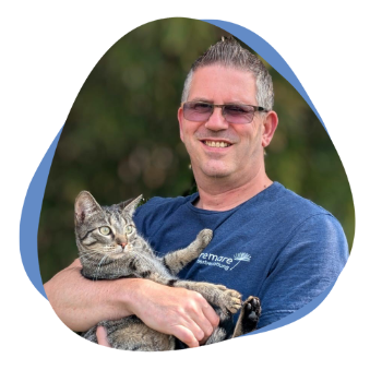 Mann mit Brille und Katze auf dem Arm