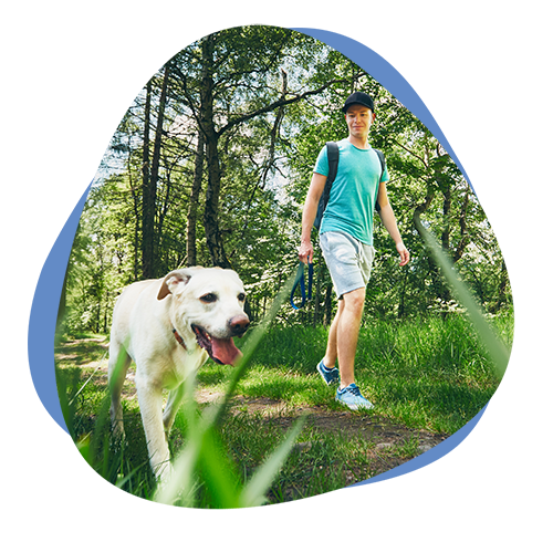 Ein Mann geht mit seinem Hund im Wald spazieren