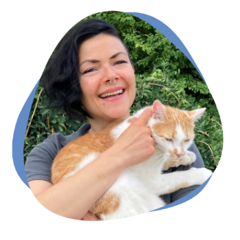 Frau mit dunklen Haaren und einem Kater auf dem Arm