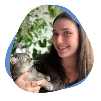 Junge Frau mit braunen Haaren und Katze auf dem Arm