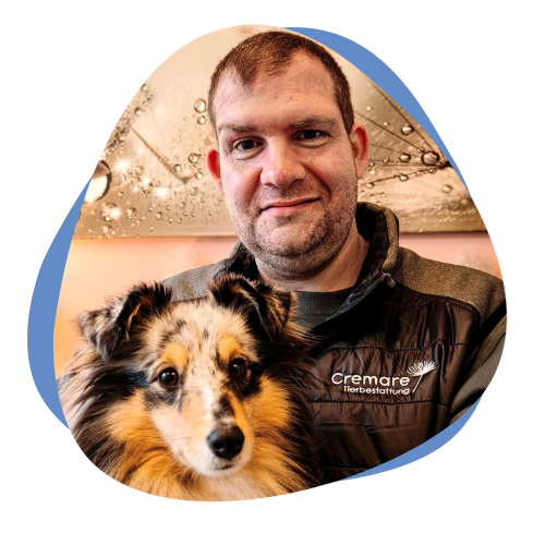 Mann mit Brille und Hund auf dem Arm